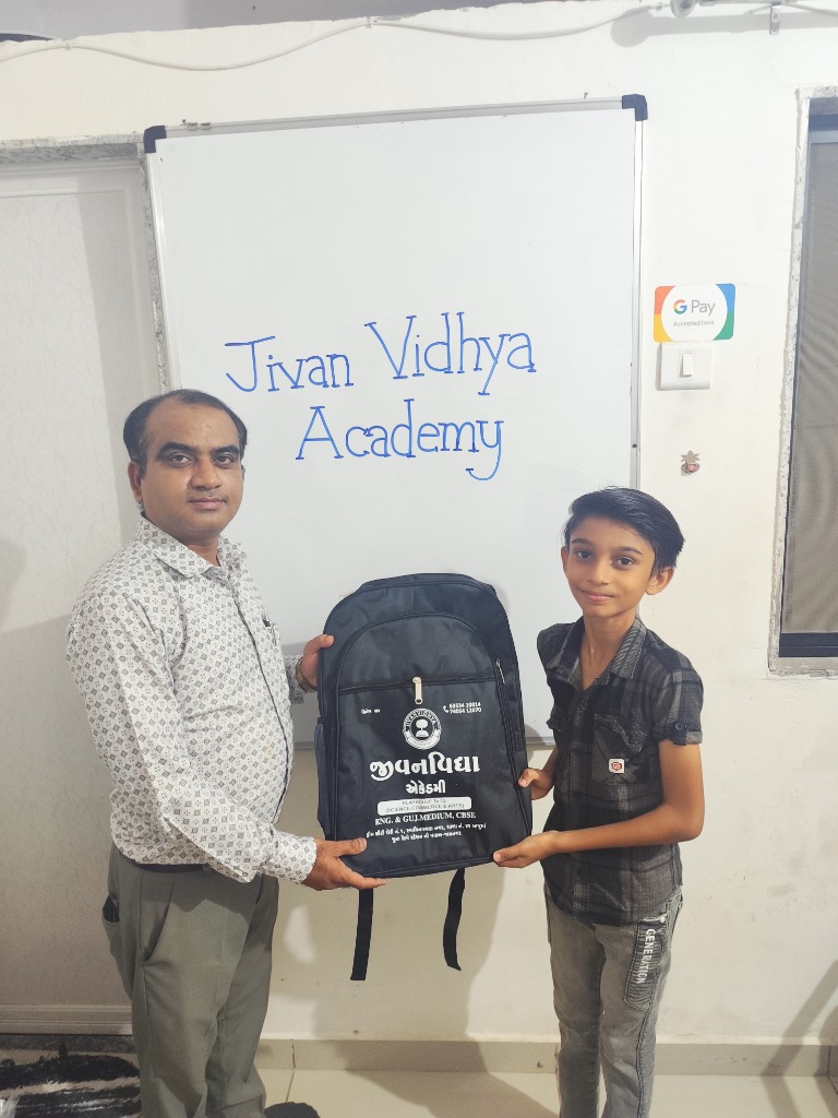 Student receiving Jivanvidhya Academy school bag in front of the academy whiteboard